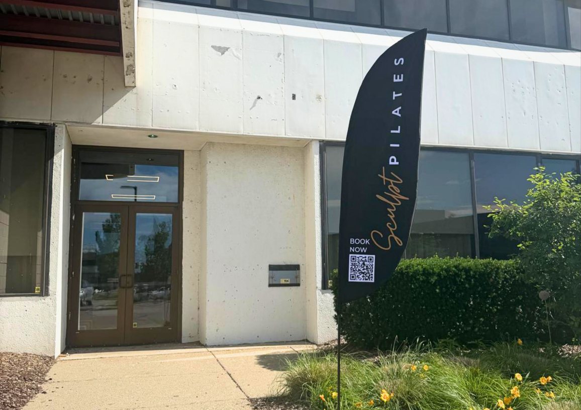 Sculpt Pilates Troy: Entrance of the Troy studio with a Sculpt Pilates flag banner