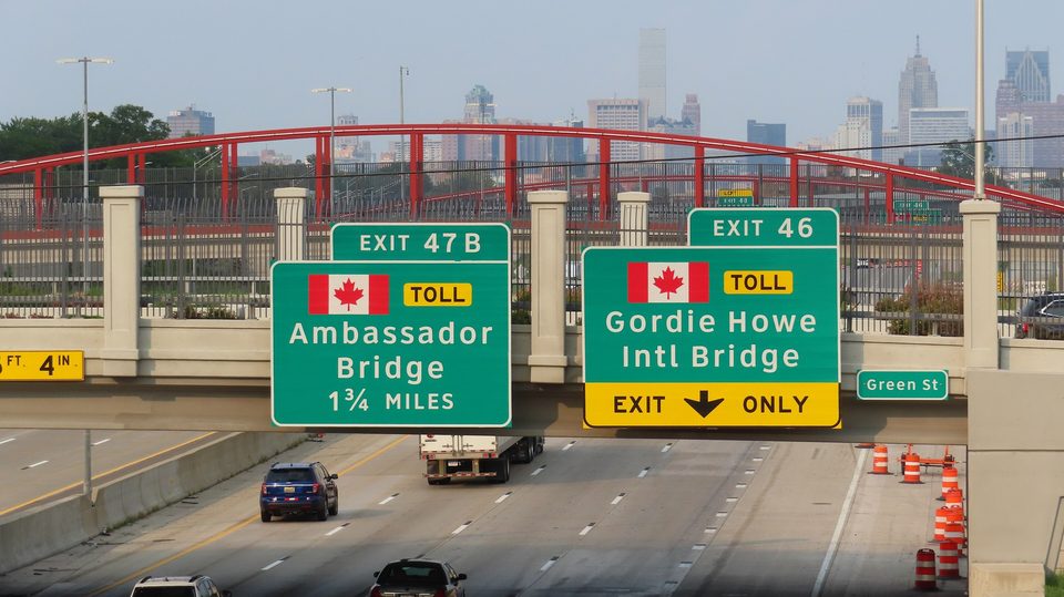 I-75 signs for the Ambassador and Gordie Howe bridges at dusk