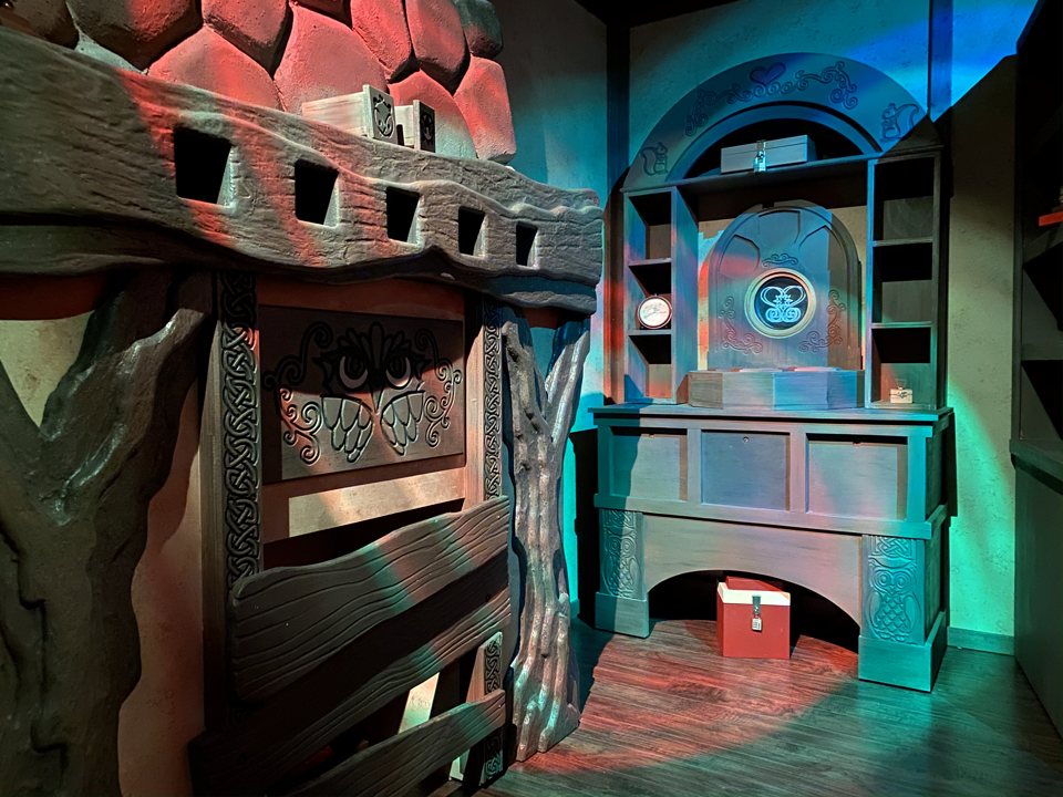 Carved owl-patterned wooden cabinets and locked boxes in a storybook-style room