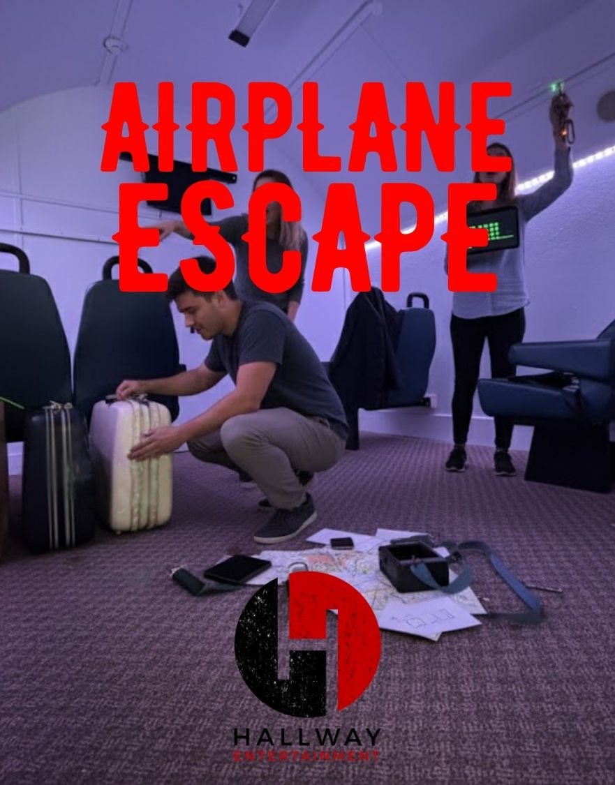 Players in an airplane cabin set, one of them examining a suitcase beside maps spread on the floor