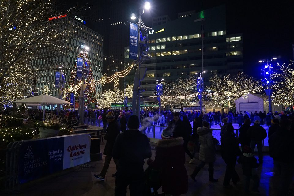 A winter night at Campus Martius Park, crowds around the ice rink