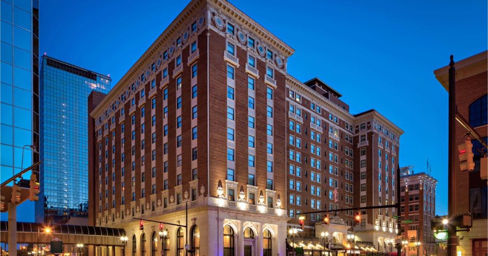 The historic Pantlind building's lit brick facade at dusk in downtown Grand Rapids