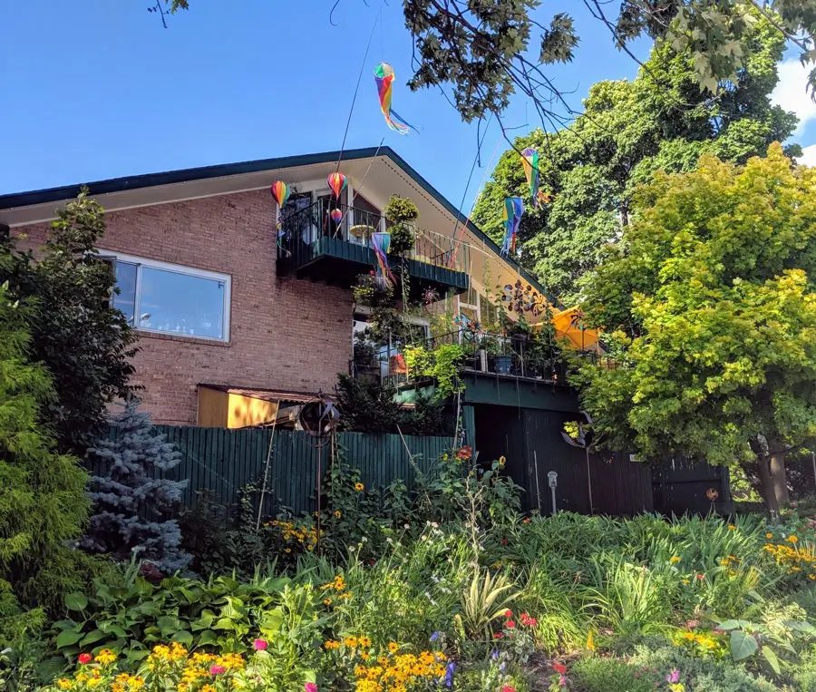 The inn's brick house with a balcony, colorful windsocks and a flower garden