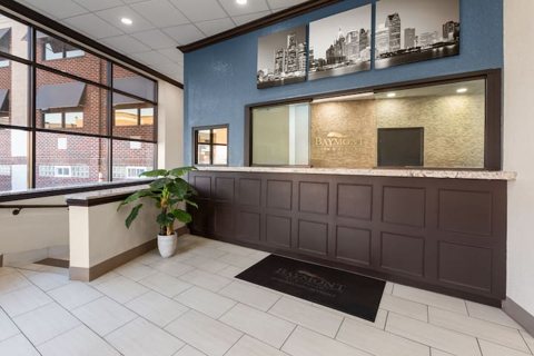 The front desk with a dark wooden counter and a tiled floor