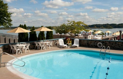 The outdoor pool with umbrellas and lounge chairs, with the river in the background