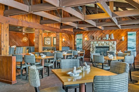 The wood-paneled River Crab dining room with a stone fireplace