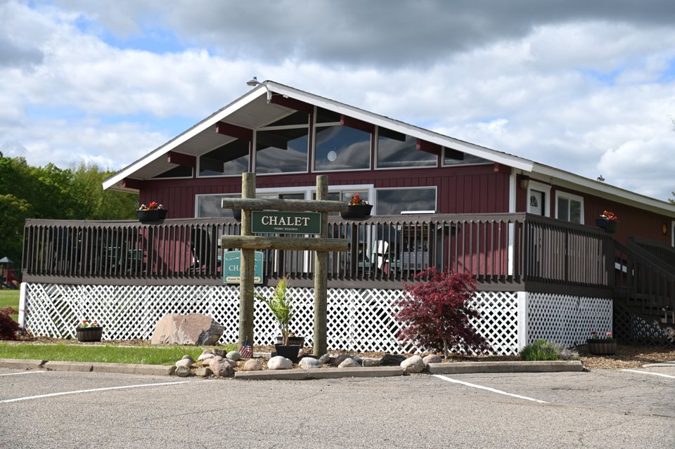 The campground's timber lodge with the parking area in front