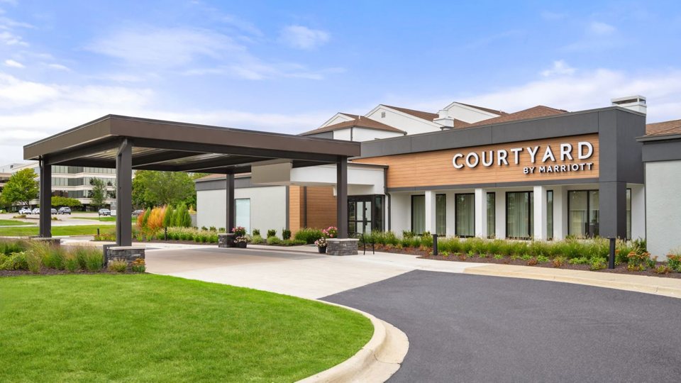 The hotel entrance with the Courtyard by Marriott sign and a drive-up canopy