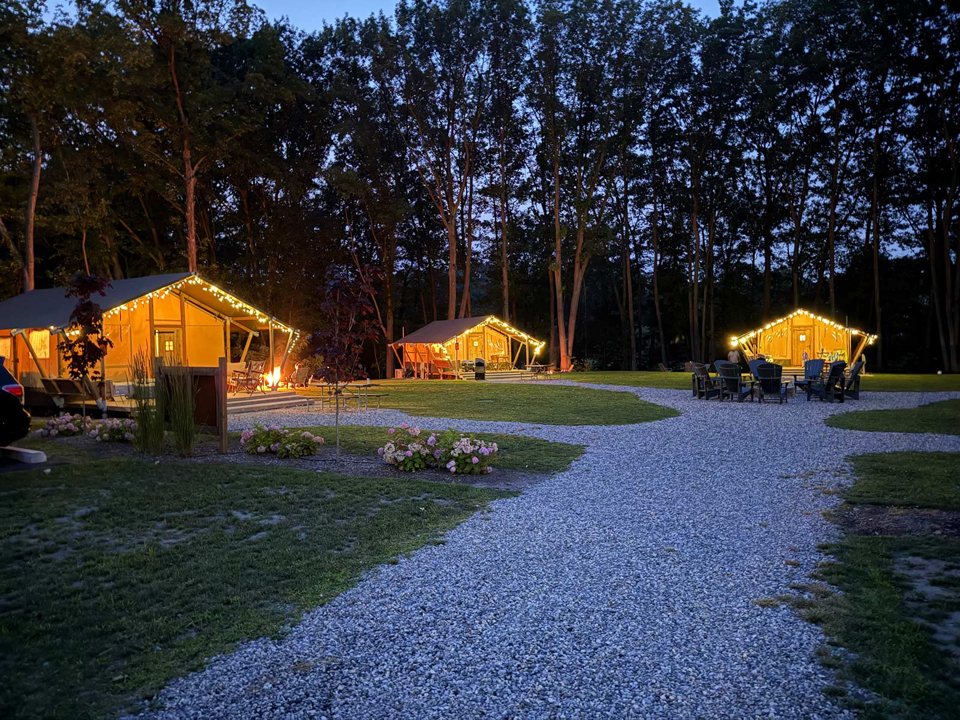 Lit glamping tents along a path in the evening