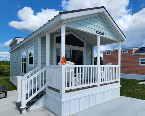 A small white cabin with a porch at the resort
