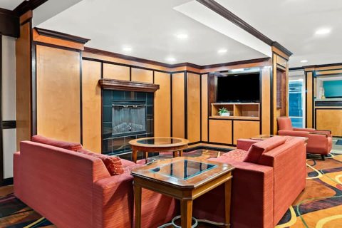 A lounge with red armchairs and a fireplace