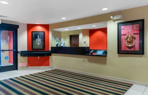 The front desk with a red wall and a striped rug