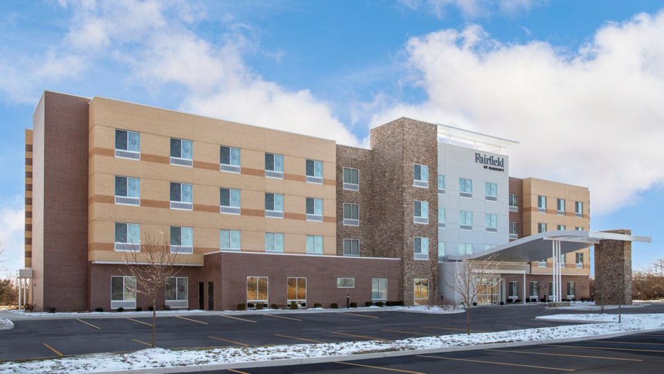 The hotel's four-storey building and entrance in winter, with a snowy parking lot