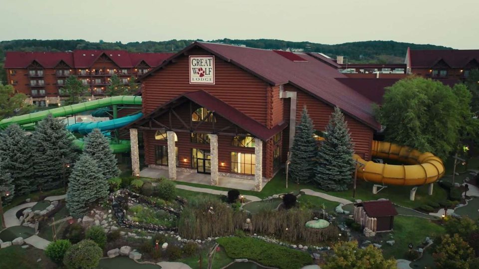 The Great Wolf Lodge's log-cabin-style building with water slides and gardens at dusk