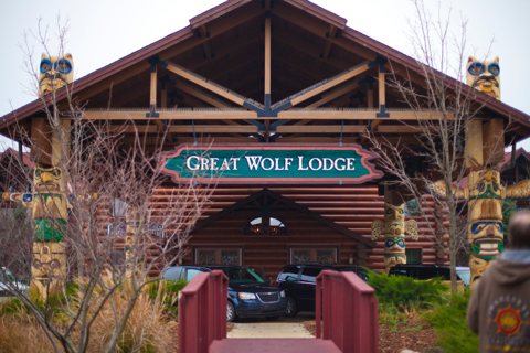 The main entrance with carved totem poles and the Great Wolf Lodge sign