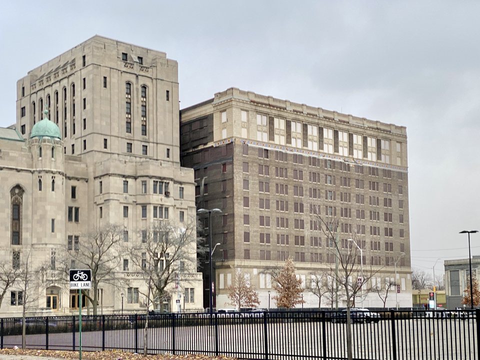 Az egykori Fort Wayne Hotel bedeszkázott ablakú téglaépülete a Cass Avenue és a Temple Street sarkán 2022-ben, balra a Masonic Temple