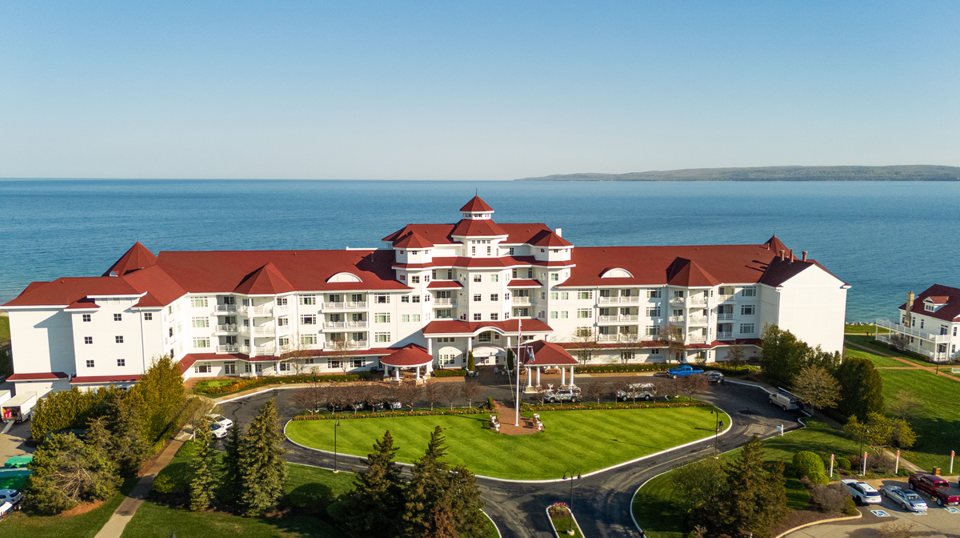 Aerial view of the white, red-roofed Inn at Bay Harbor on Little Traverse Bay