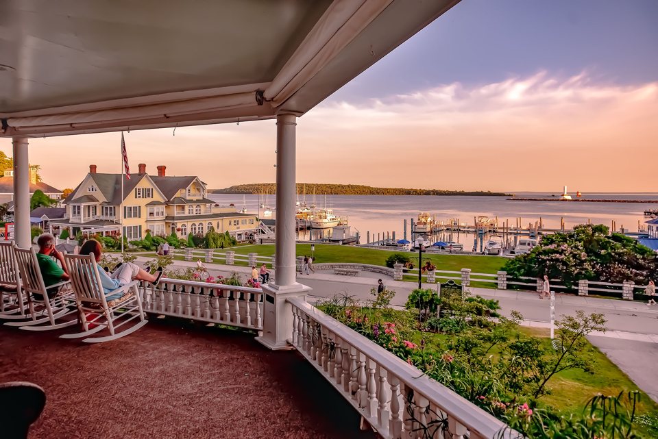 View from the Island House porch with rocking chairs over the Mackinac Island harbor at sunset