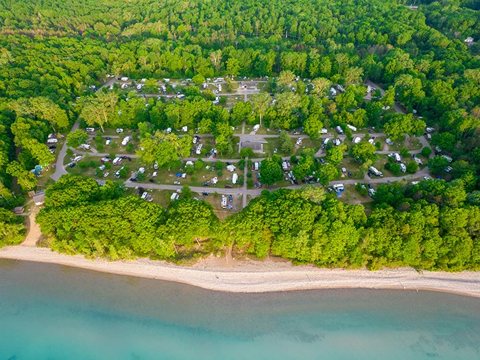 Aerial view of the wooded campground and the Lake Huron shore