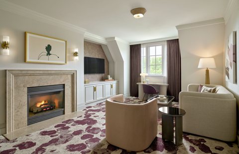 A suite living room with a fireplace, sofa and armchairs