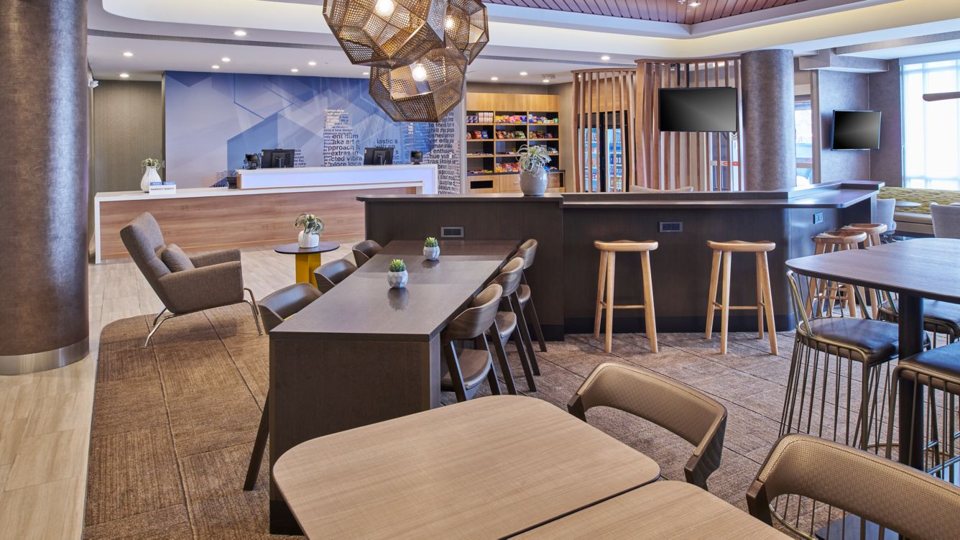 The lobby with dining tables, bar stools and seating