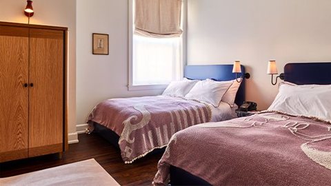 Vendégszoba két ággyal, fa ruhásszekrénnyel és ablakkal