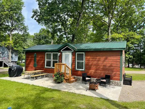 A red and brown cabin on the lawn