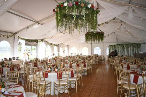 Decorated tent hall with flowers and set tables