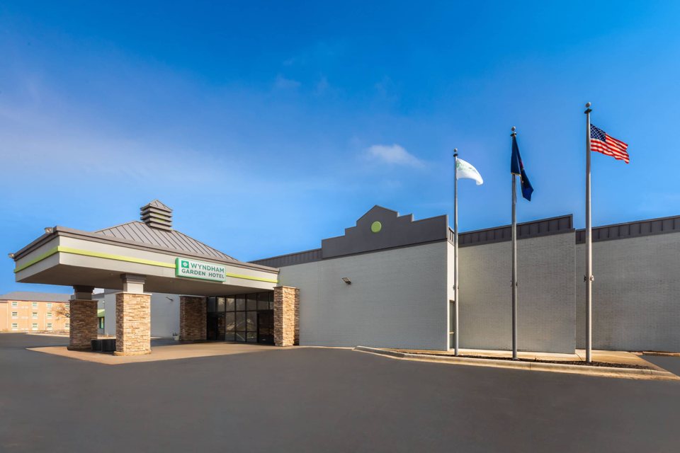 The hotel's entrance canopy and flagpoles under a blue sky