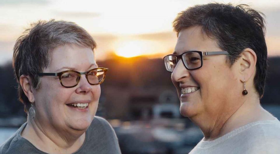 Two smiling older women at sunset