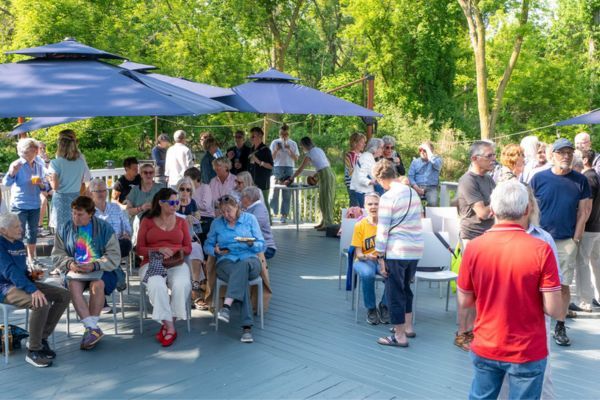 Guests mingling under umbrellas on an outdoor deck