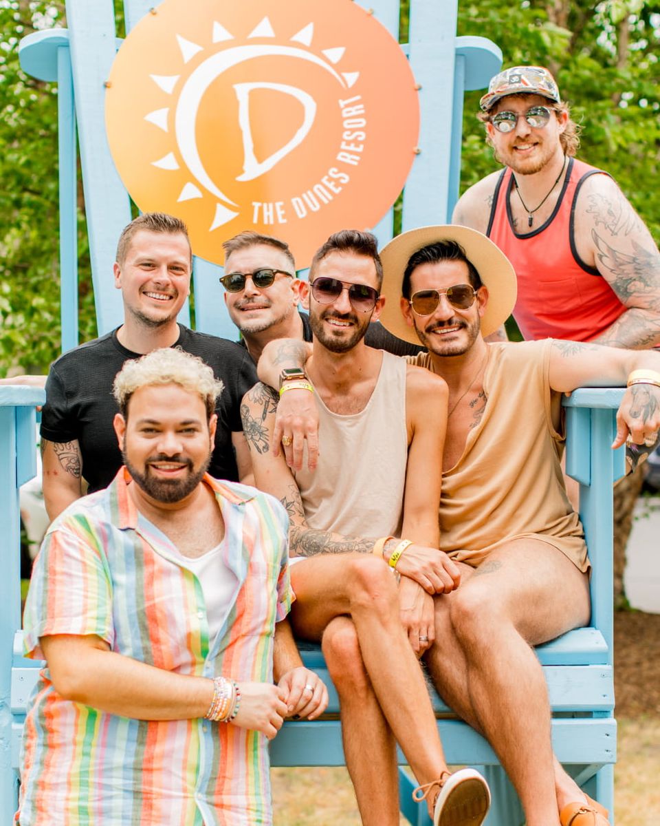 Group of friends posing on The Dunes Resort's giant lawn chair