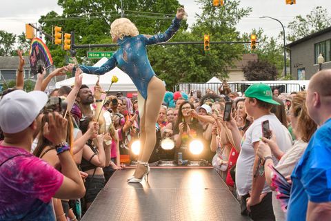 Drag performer in a sparkly blue bodysuit on the Ferndale Pride runway amid the crowd