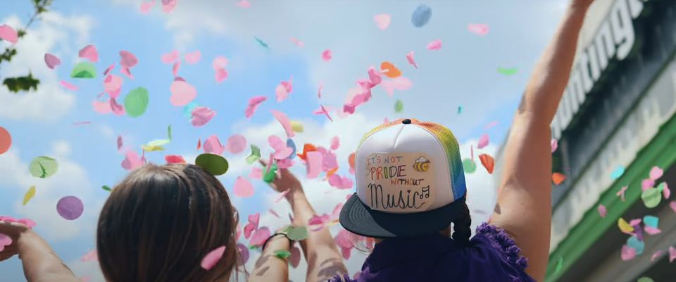 Colorful confetti flying over raised hands at the festival