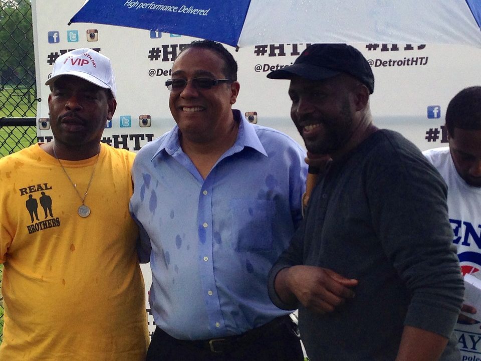 Participants at Hotter Than July 2013 in front of a #HTJ backdrop