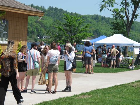 Festivalgoers in the lakeside park with tents at Keweenaw Pridefest