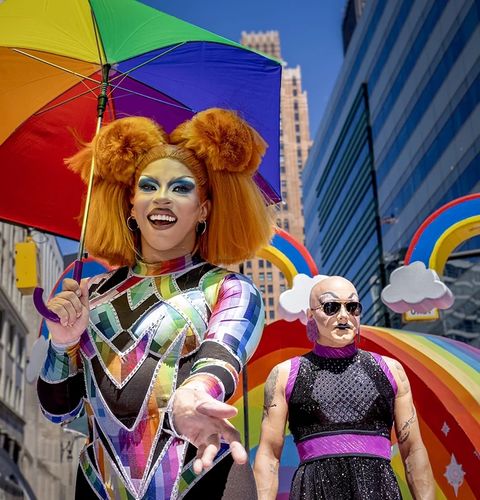 Drag performer in a rainbow outfit with a rainbow umbrella at Motor City Pride