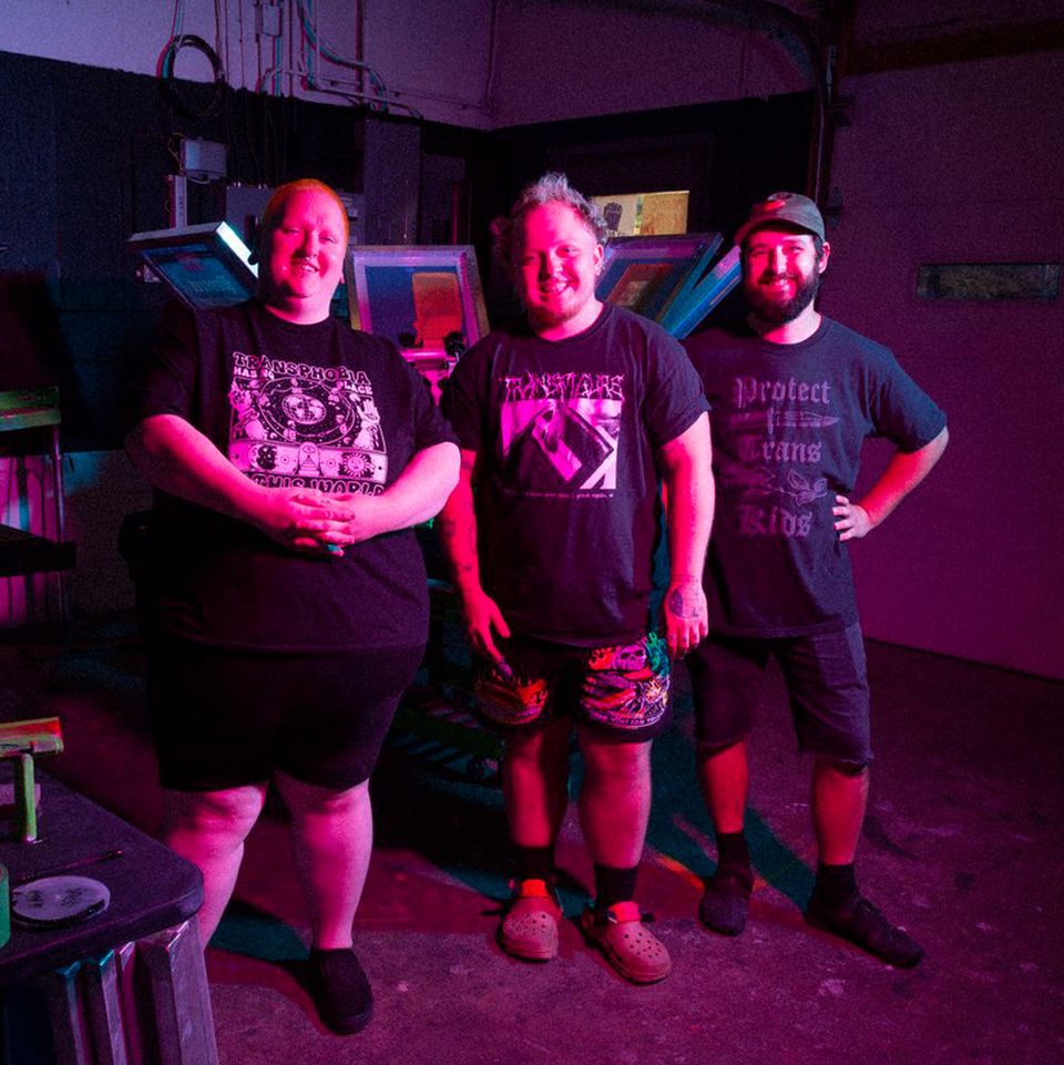 The print shop team in the studio under pink lighting