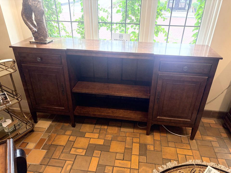 Dark wood sideboard on a tiled floor