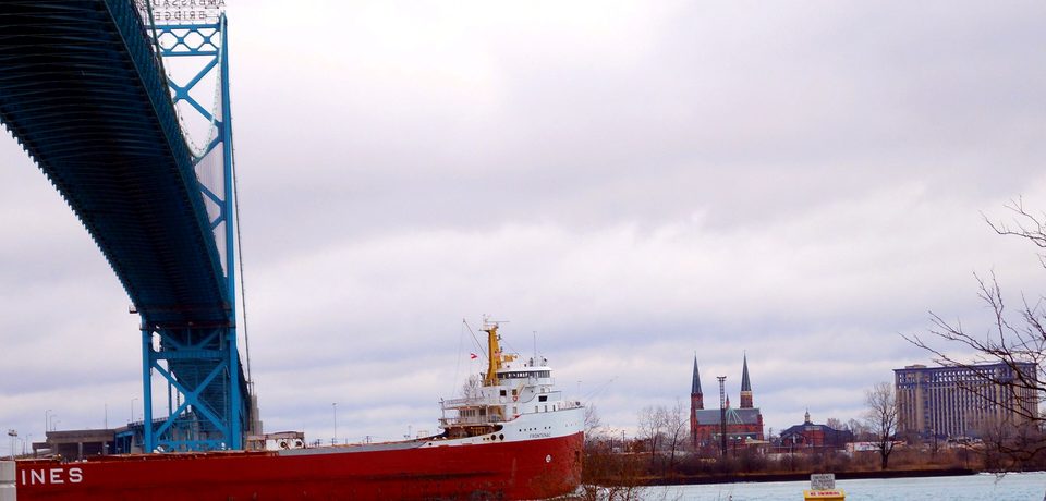A freighter under the Ambassador Bridge, the station tower in the distance