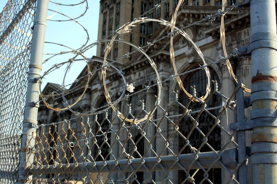 Razor wire on the fence before the abandoned facade, 2010