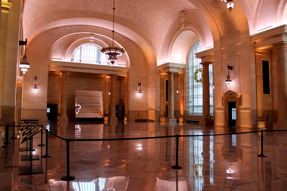 The restored waiting room with chandeliers and a polished floor, 2025