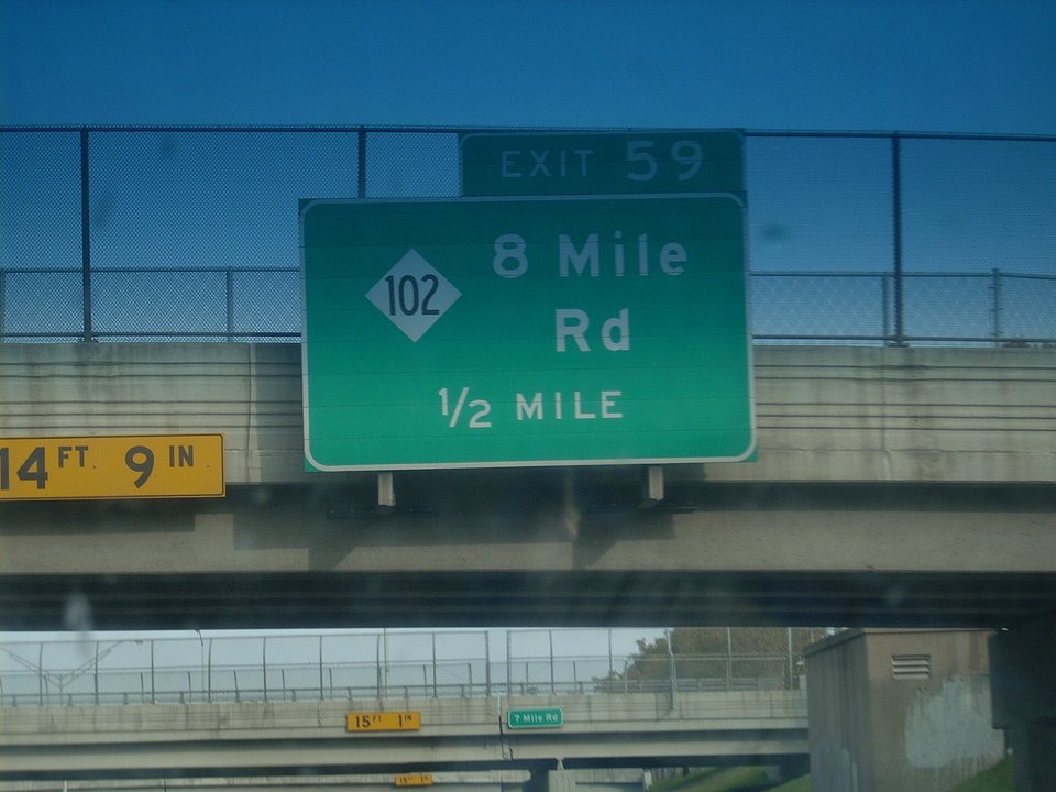 A green 8 Mile Rd street sign