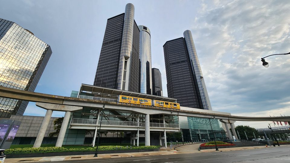 Sárga People Mover-szerelvény a Renaissance Center állomáson, fölötte a tornyok (2025)