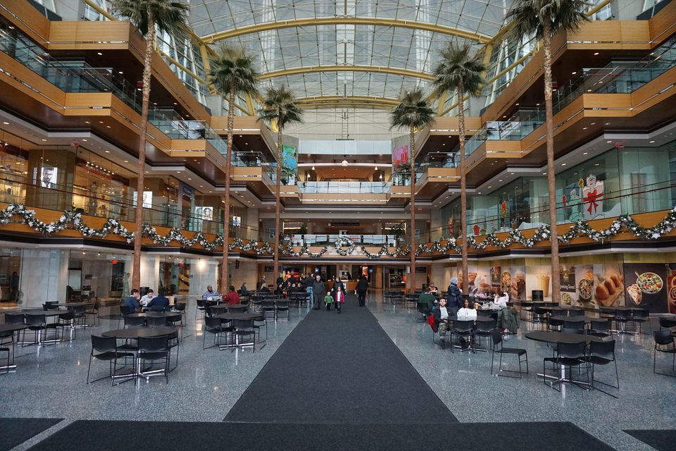 A Wintergarden ötszintes üvegcsarnoka pálmafákkal, asztalokkal és karácsonyi füzérekkel, 2015 decemberében