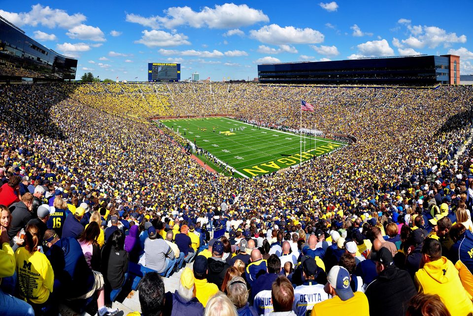 A packed Michigan Stadium under blue skies, a sea of maize-and-blue fans