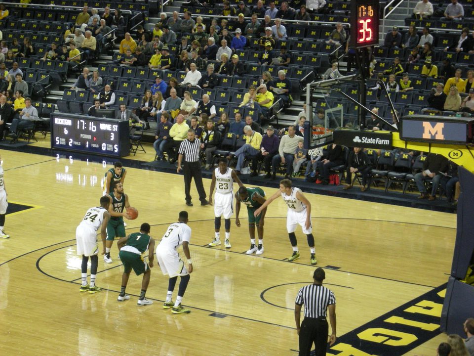 Players line up for a free throw as Wayne State, in green, takes on Michigan