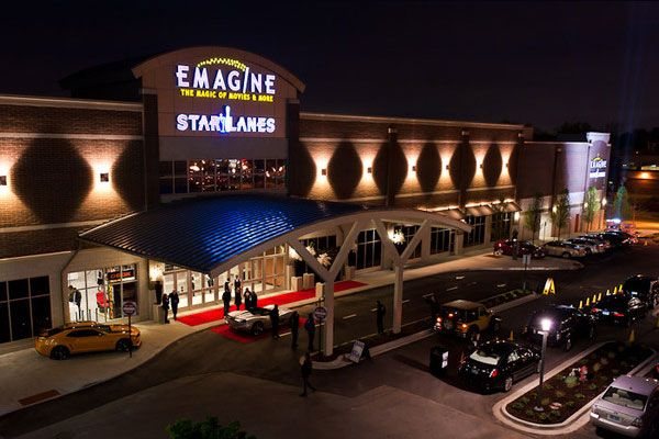 Az Emagine és a Star Lanes épülete éjszaka, felülről: vörös szőnyeg, kivilágított előtető és autók a bejárat előtt