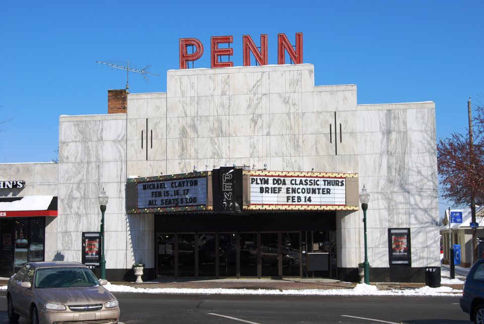 A Penn Theatre fehér homlokzata és márkiza napsütésben, kék ég alatt