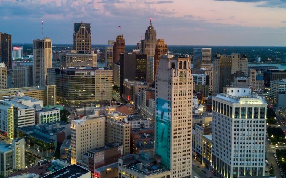Detroit belvárosának látképe szürkületkor, kivilágított felhőkarcolókkal